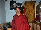 Mustang Lo Manthang 03 06 Chyodi Gompa Lama Lodu Tenzin In His Apartment I was just sitting in the courtyard of Chyodi gompa waiting for the right conditions for a photo when an old Lama waved to me to come visit his room. Lama Lodu Tenzin showed me all his meager possessions at Chyodi Gompa in Lo Manthang - a few old thangkas, a begging bowl (although they don't beg here), a few old photos, and so on. The Lama smiled all the time with two big fangs and lots of gum. He gave me a kata and I promised to send him the photos I took of him. I recognized him because he sits at the head table with 11 other senior monks at the Tiji Festival.